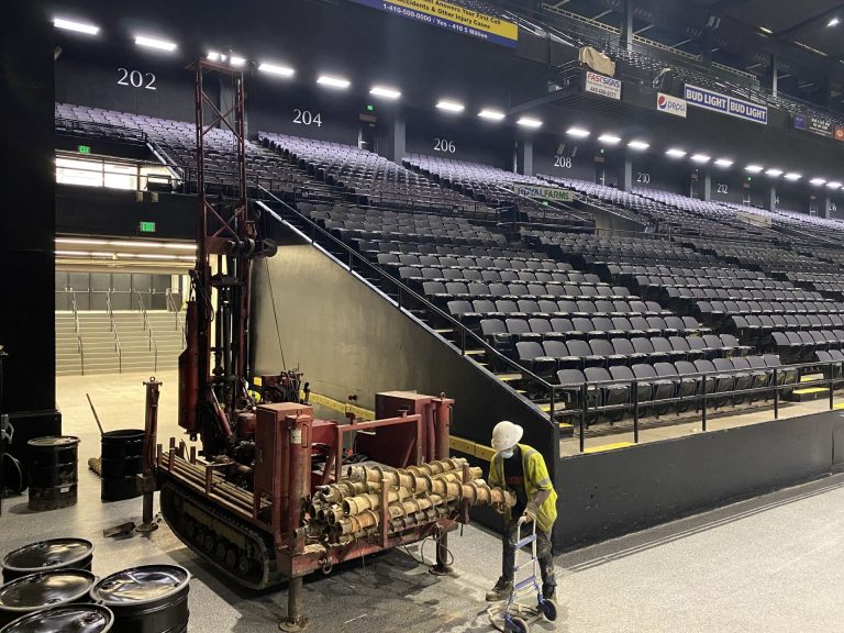 Geotechnical drilling rig performing subsurface investigation inside an arena to evaluate soil conditions for foundation design