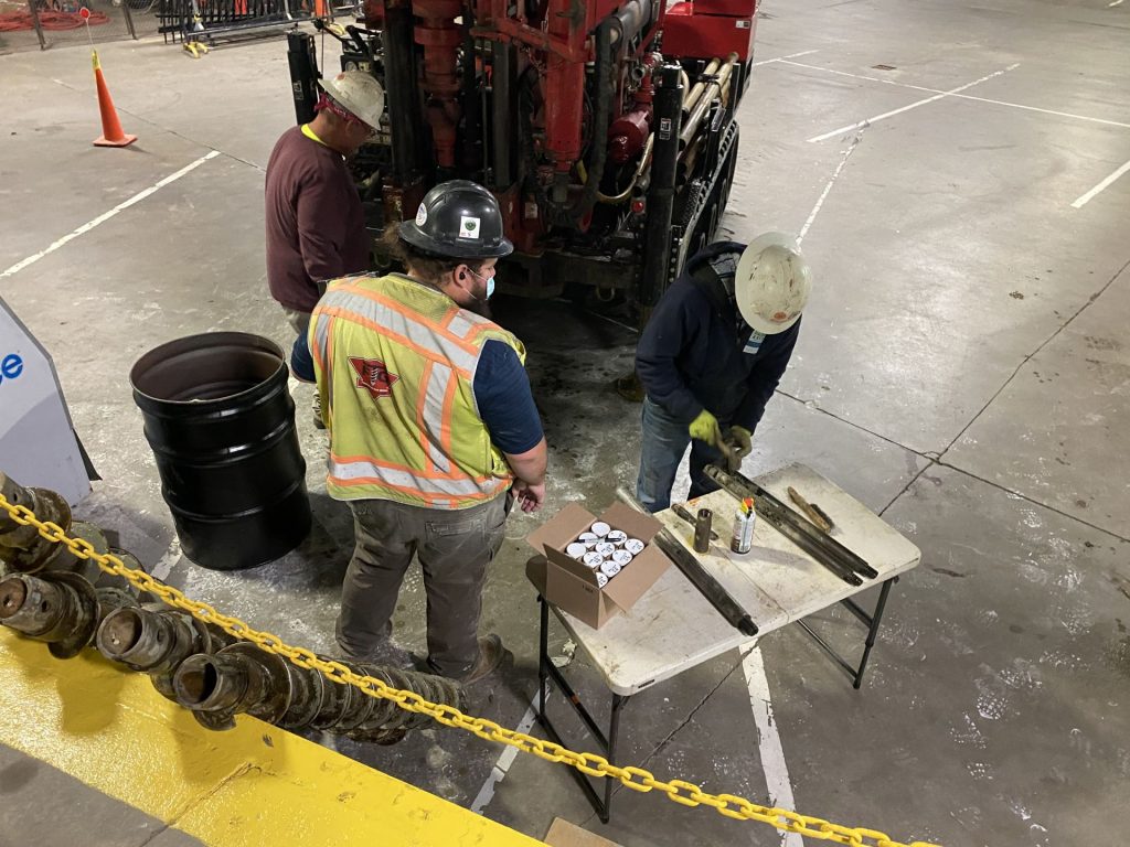 Engineers labeling and preparing soil samples collected during geotechnical drilling for further analysis