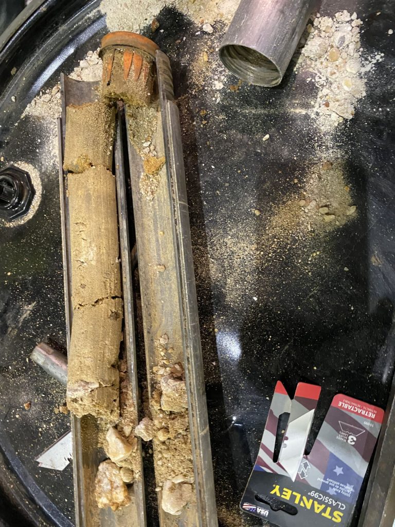 Close-up of soil core sample showing layers of sand and aggregate collected during a geotechnical investigation