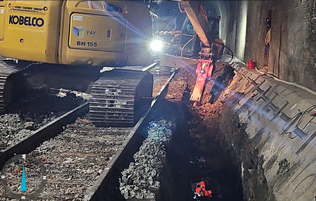 Excavation for a 920-ft dual-line drainage pipe installation progressed along both sides of the existing tunnel